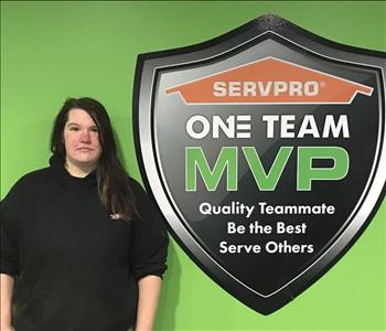 Female employee standing by SERVPRO sign