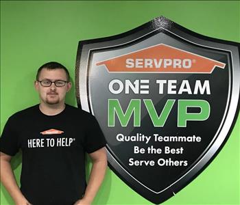 Male employee in front of SERVPRO One Team signage