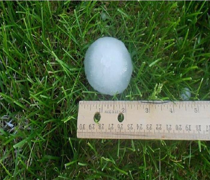 A piece of hail with ruler.